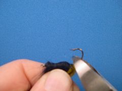 Remove the tail from the vice.  Remove the back part of the hook with a pair of side-cutters as shown.  Get as close to the material as you can but don't cut the thread wraps.